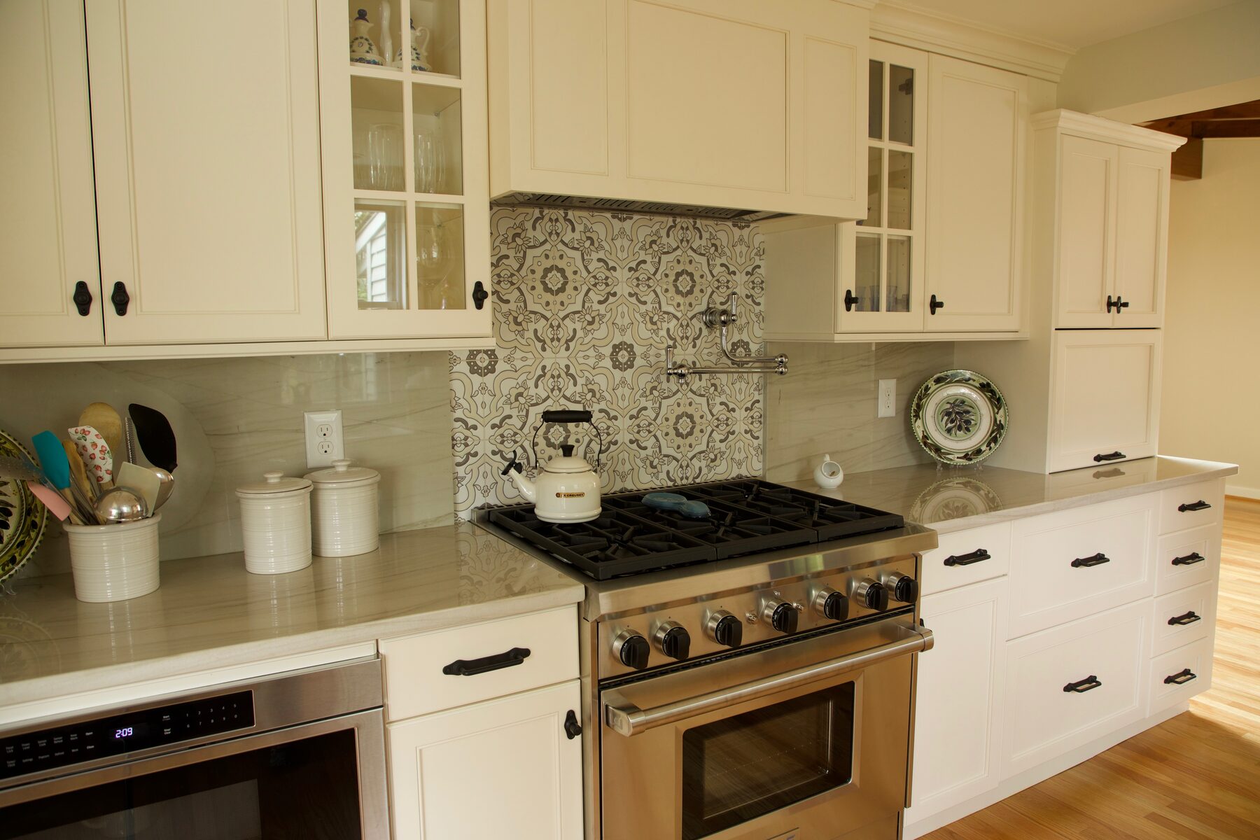Cream inset kitchen cabinets with custom range hood