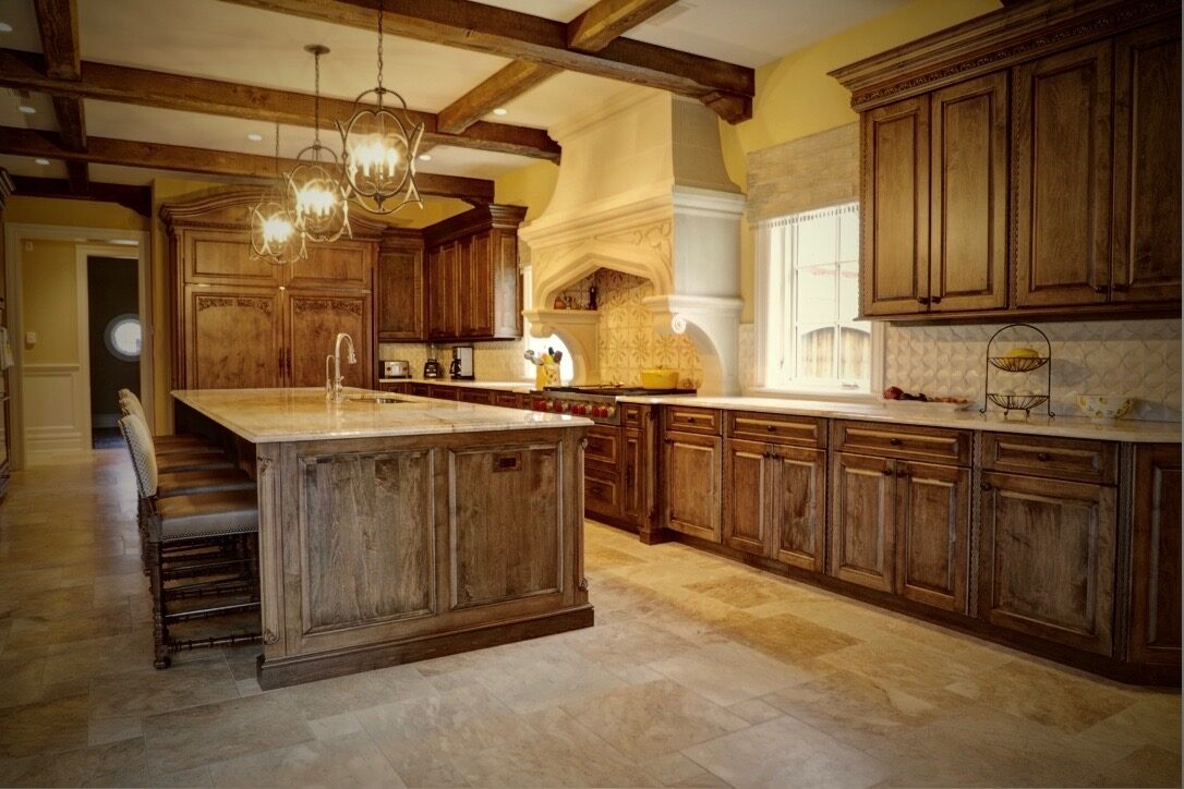 Traditional stained wood kitchen with a large island and stone hood